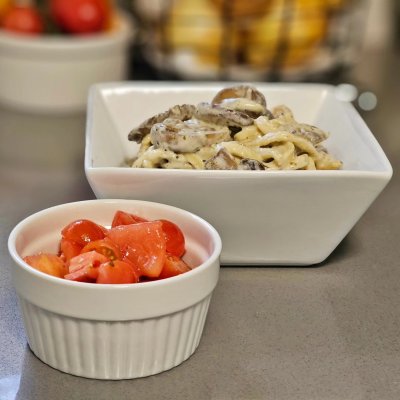 Homemade linguini in a white wine, mushroom, cream sauce with fresh thyme. A side of homegrown tomato salad.