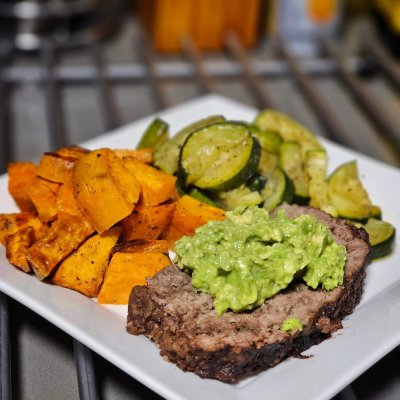 Meatloaf topped with guacamole, roasted sweet potatoes,  and roasted zucchini. Root beer in a frozen mug to go with.
