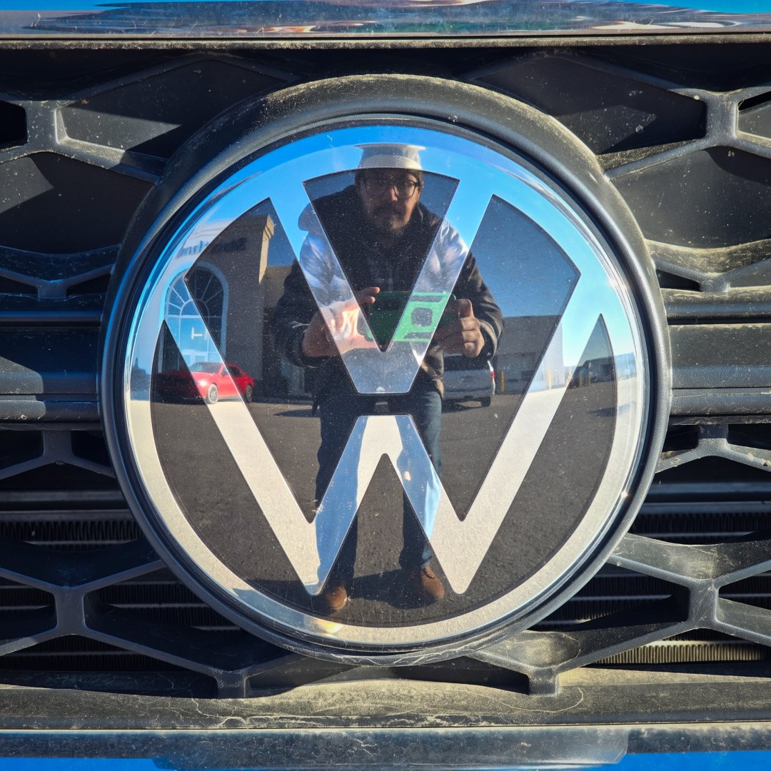 Man reflected in Volkswagen logo